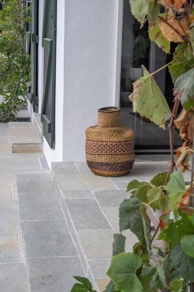 Seuil en dallage Tandur devant une porte-fenêtre, panier tressé et feuilles de vigne